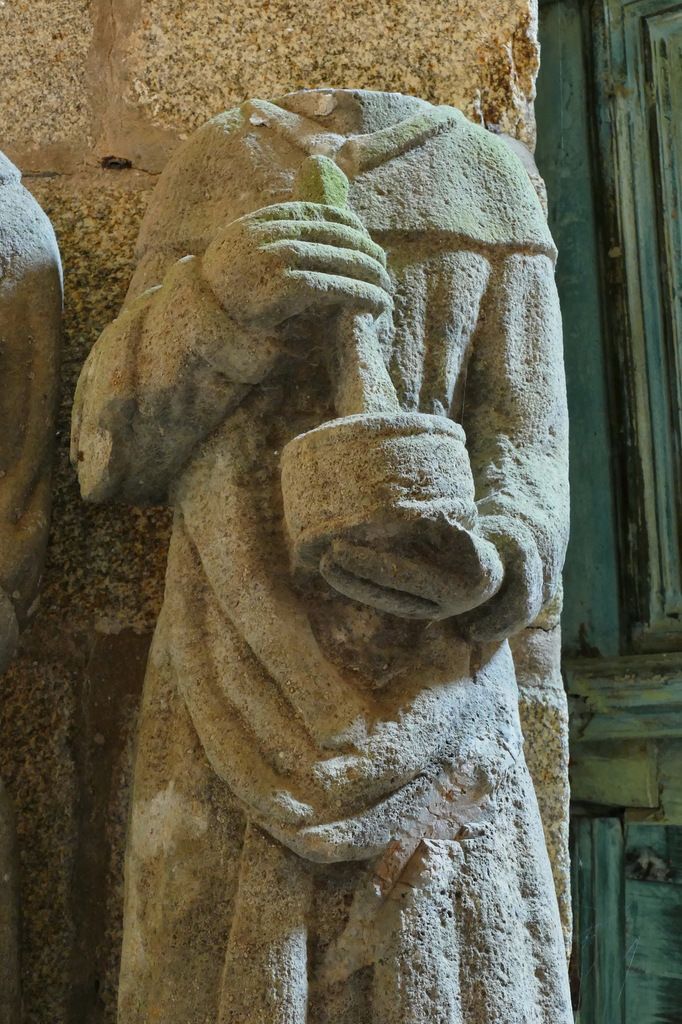 Saint [Damien] tenant un pilon et un mortier, kersanton, chapelle Saint-Côme et Saint-Damien, Saint-Nic. Photographie lavieb-aile 3 juin 2018.