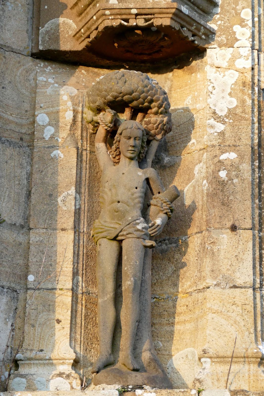 Saint Sébastien, (XVIe siècle, kersanton, Bastien Prigent) niche du contrefort droit du Piédroits du  porche sud  de l'église Saint-Pierre de Ploudiry. Photographie lavieb-aile.