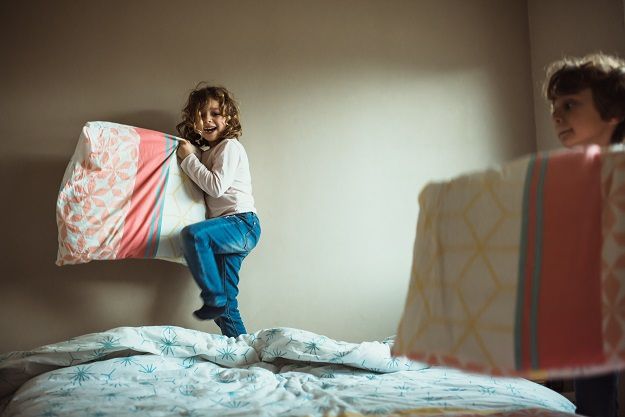 photos d'enfants qui font une bataille d'oreillers