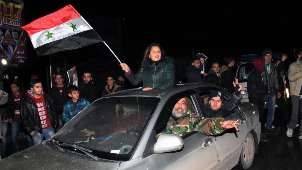 Des Syriens dans les rues d’Alep jeudi 22 décembre pour célébrer la reprise en main de la ville pour le régime Assad.Georg