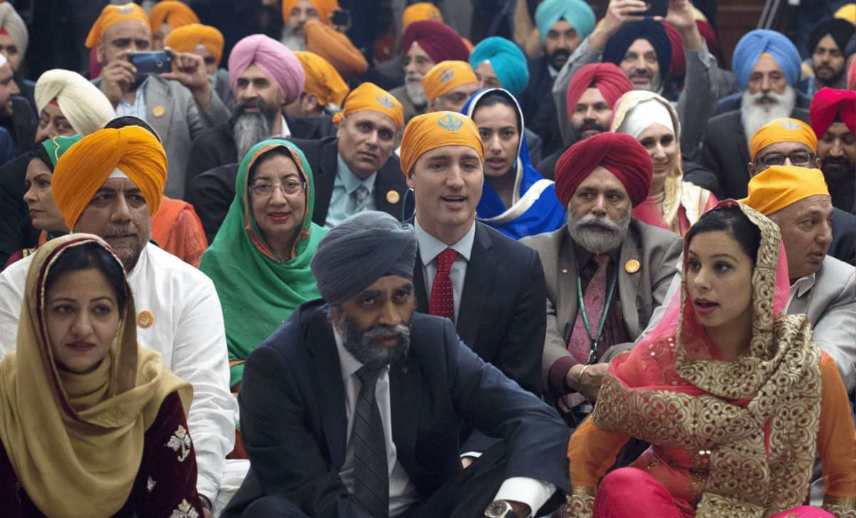 Trudeau 1er Ministre, fait le ridicule à la Fillon, avec un bandeau Sikh. Son voisin le regarde curieusement.