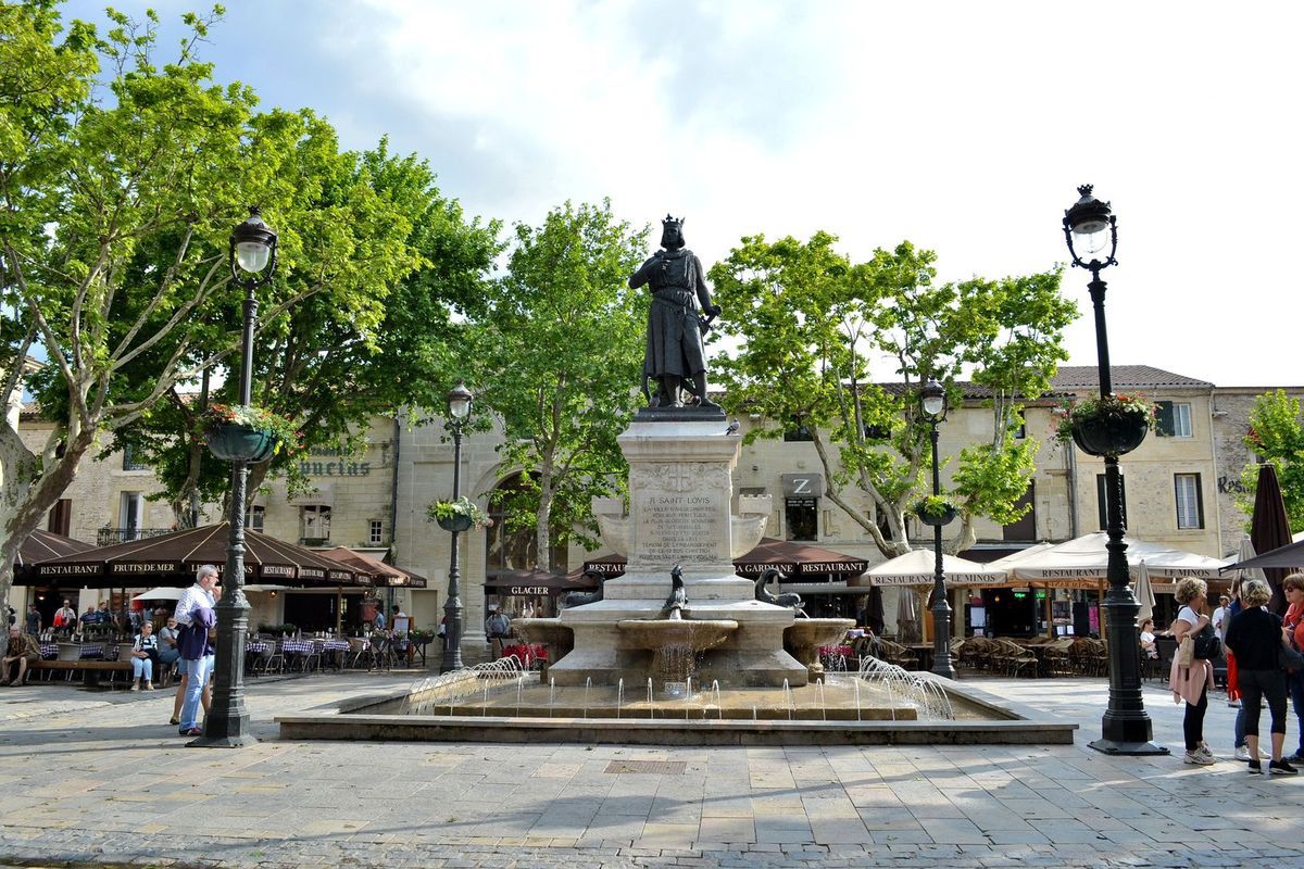 La rue Jean Jaurès, principale artère commerçante d'Aigues-Mortes, menant à la Place Saint-Louis et sa statue du célèbre roi. 