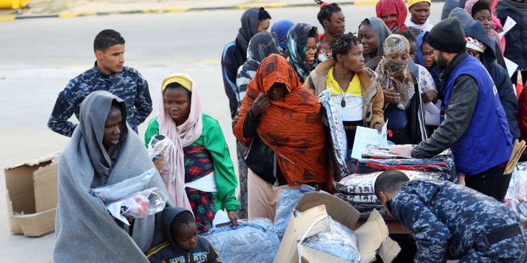 Des migrants subsahariens lors d’une distribution de vêtements dans un camp de rétention de la banlieue de Tadjourah, à l’est de Tripoli, en Libye, le 5 décembre 2017