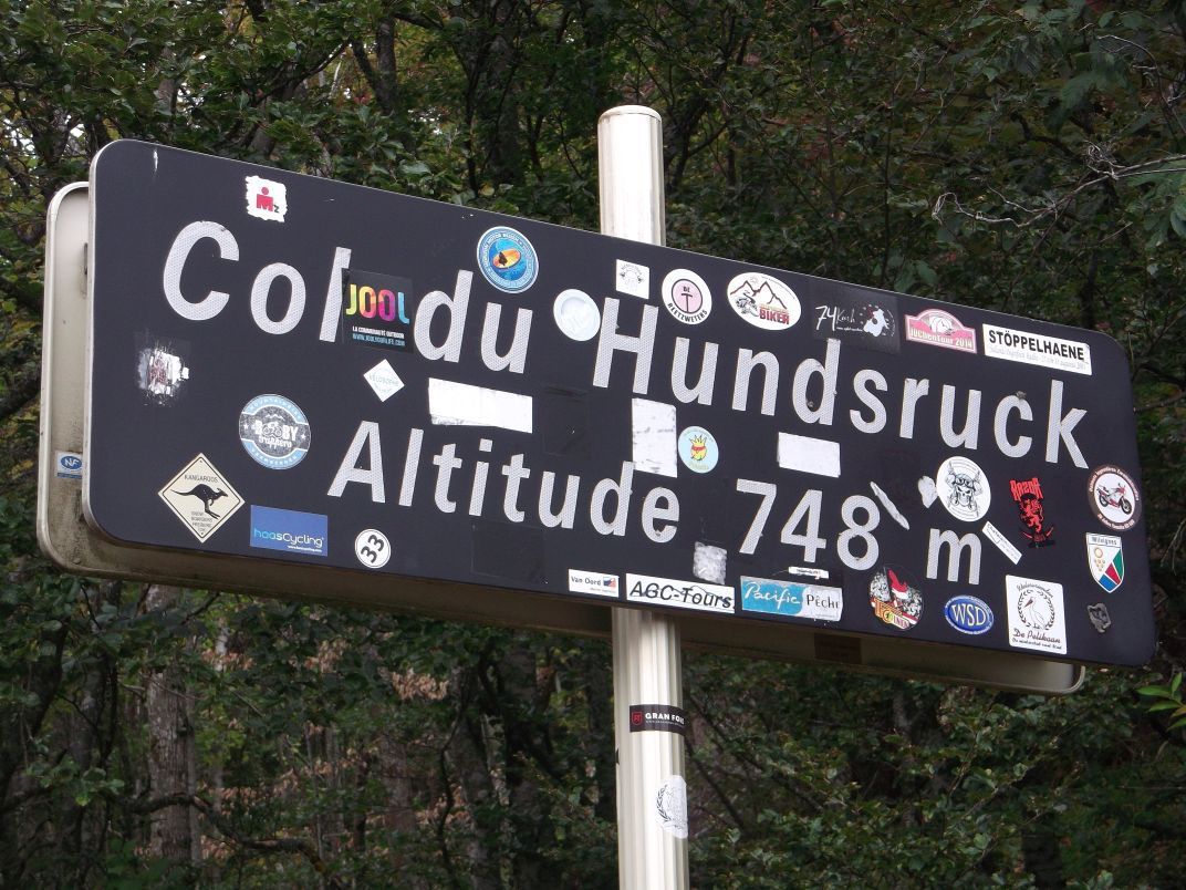 Le village de Bourbach-le-Haut, et le panneau du col, que les cyclistes décorent classiquement (9). avec les autocollants de leurs clubs.