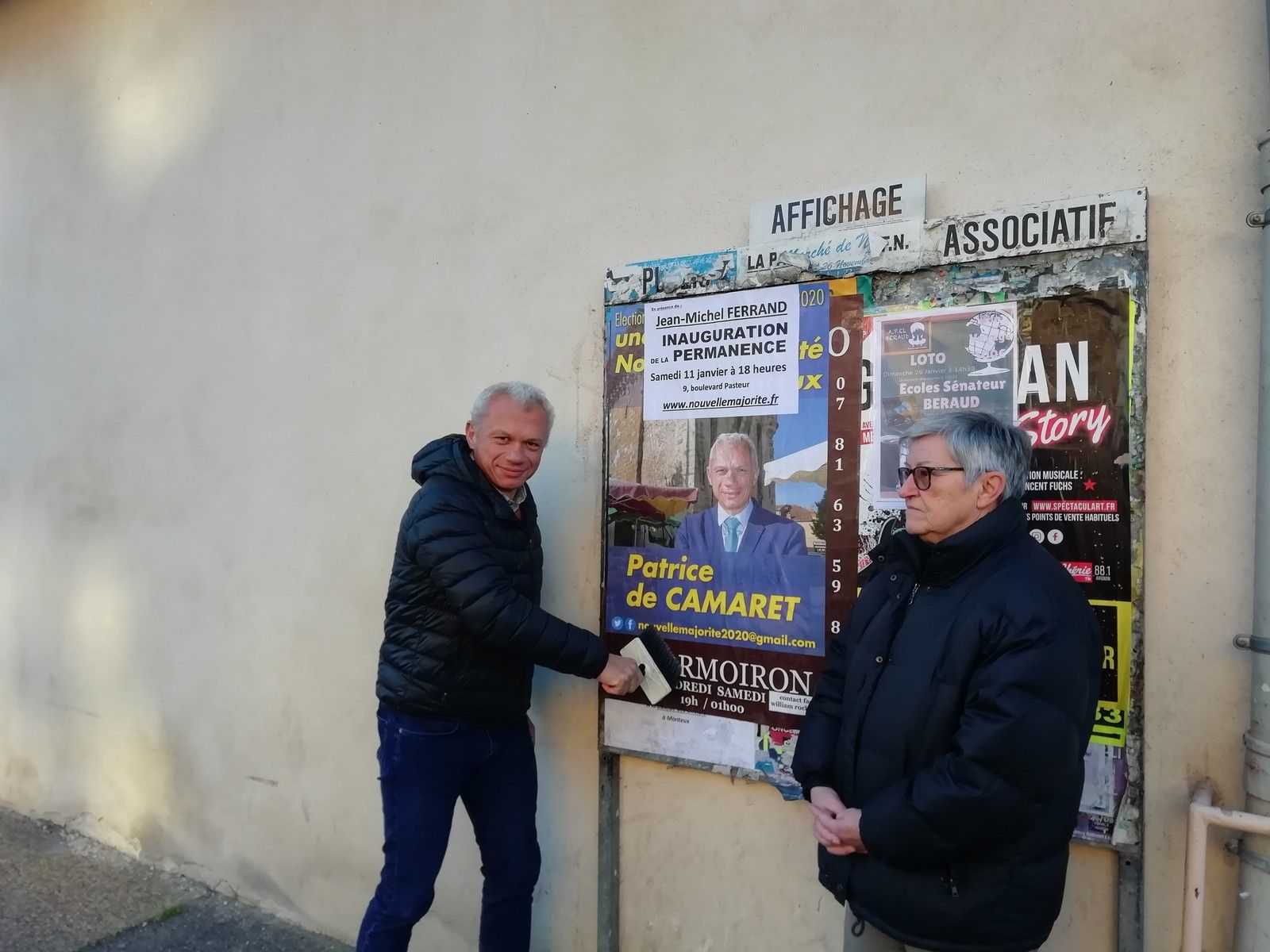 Patrice de Camaret collant ce matin une affiche sur l'inauguration de samedi