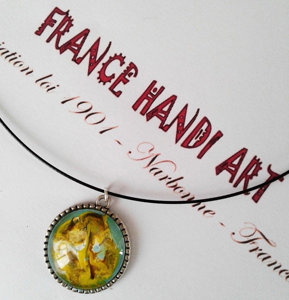 pendentif rond, le fauve et l'arbre de vie, doré jaune marron,vert blanc bleu,peinture sur bijou, cabochon rond verre 25mm,cordon acier gainé noir,fermoir magnétique,oeuvre original d'isabelle krief pour lacik france handi art, regardez bien on voit comme un chat, un tigre, un fauve, un félin, l'abstrait permet tout, regardez bien.