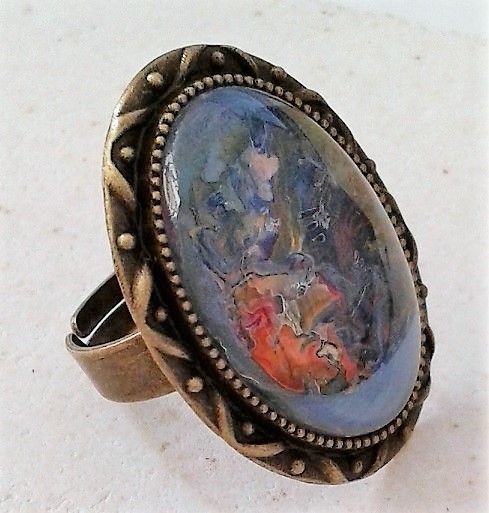 Mini tableau original abstrait de 18x25mm sur bague réglable bronze vieilli, nickel free, tons bleu, orange, vert, mauve, parme, rouge, blanc, gris, volutes de teintes et de lumières qui se croisent et s'entrecroisent pour nous faire parcourir notre imaginaire. bijou de légende, bijou fantastique, bijou peint, bijou féérique, bijou atypique, bijou unique, bijou d'artiste, bijou artistique, bijou bleu, bijou orange, bijou gris, bijou bronze. Création de l'atelier france handi art, narbonne, fait mains en France.