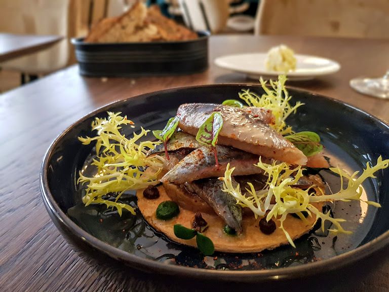 Sashimi de sardines fumées à la japonaise en pissaladière feuilletée, condiment olives et raifort Miura restaurant Paris 17