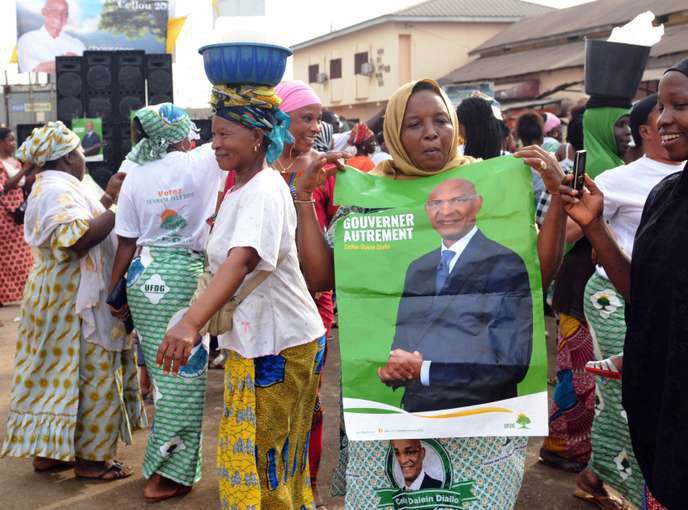 A Conakry, une affiche du leader de l’Union des forces démocratiques de Guinée (UFDG), Cellou Dalein Diallo, brandie lors d’un meeting de campagne à l’occasion des élections municipales de février 2018. CELLOU BINANI / AFP