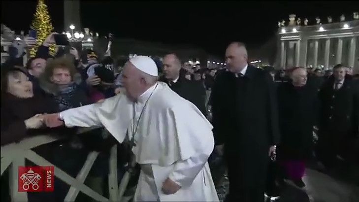 Une fidèle saisit le bras du pape François, le 31 décembre 2019 sur la Place Saint Pierre. Capture d'écran à partir d'une video fournie par le service de presse du Vatican / VATICAN MEDIA/AFP