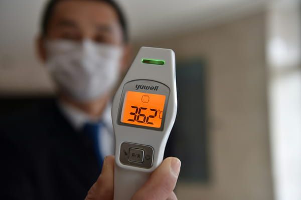 AFP Un employé chargé de prendre la température des clients de l'hôtel Marco Polo, le 29 janvier 2020 à Wuhan, en Chine © AFP - HECTOR RETAMAL