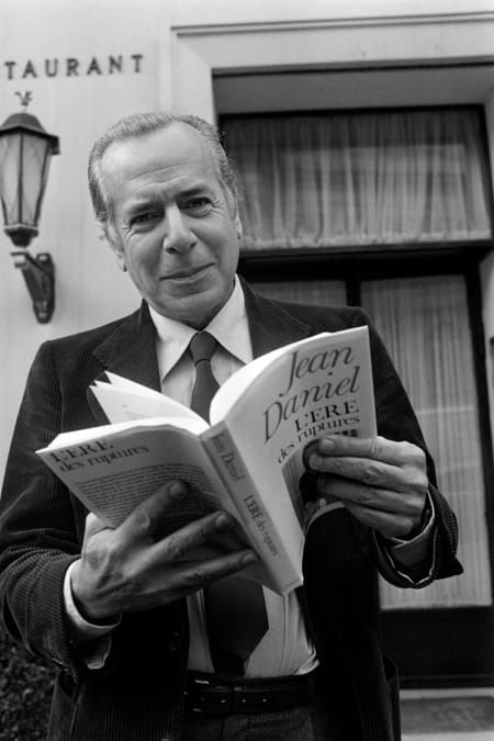 AFP Le journaliste Jean Daniel avec l'un de ses livres "L'ère des ruptures", le 10 octobre 1979 à Paris © AFP - Georges BENDRIHEM