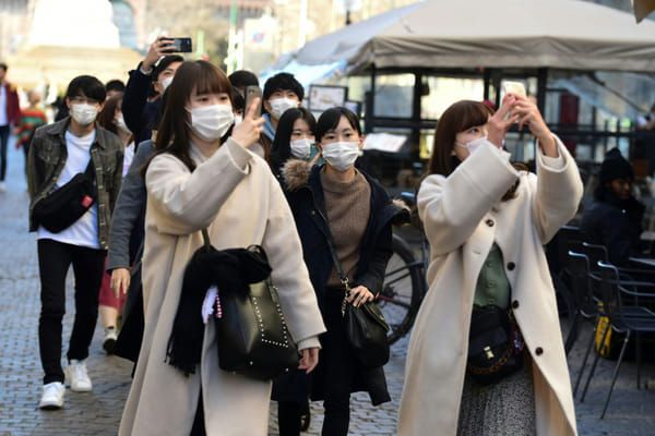 AFP Des touristes portent des masques de protection contre le Covid-19 dans les rues de Milan, le 28 février 2020 © AFP - Miguel MEDINA
