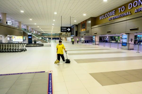 Une employée du nettoyage dans le terminal désert des arrivées à l'aéroport international de Don Mueang de Bangkok, le 22 mars 2020 © AFP - Mladen ANTONOV