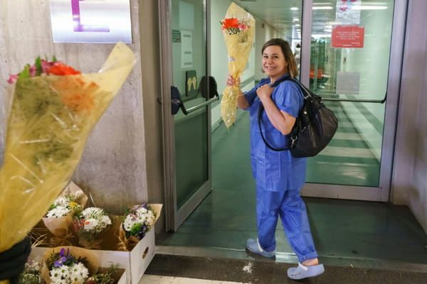 Un membre du personnel soignant de l'hôpital de Burgos (nord de l'Espagne) reçoit un bouquet de fleurs en signe de remerciement, le 21 mars 2020 © AFP - CESAR MANSO