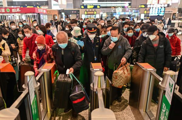 Des voyageurs portant des masques de protection contre le coronavirus s'apprêtent à monter dans un train à destination de Wuhan, le 28 mars 2020 à la gare de Shanghai © AFP - Hector RETAMAL