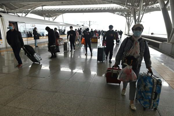 Des voyageurs descendent d'un train à la gare de Wuhan, le 28 mars 2020 dans la province chinoise du Hubei © AFP - HECTOR RETAMAL
