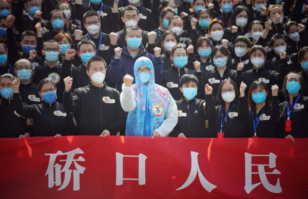 Des équipes médicales de la province de Jiangsu venues aider le Wuhan, dans la province du Hubei, participent à une cérémonie d'au-revoir lors de leur départ le 19 mars 2020 © AFP - STR