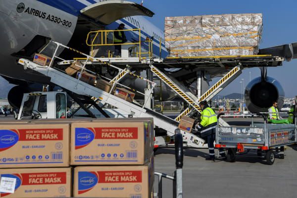Des cartons contenant quelque 500.000 masques venus de Chine sont déchargés de l'avion Air China, sur l'aéroport d'Athènes, le 21 mars 2020 © AFP - ARIS MESSINIS