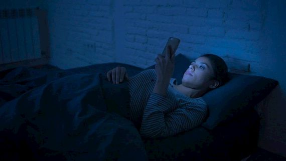 woman using mobile phone before sleeping