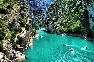 eau verte, rochers, arbres, bateaux