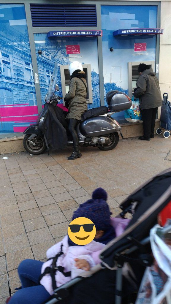 Femme sur un scooter sur un trottoir