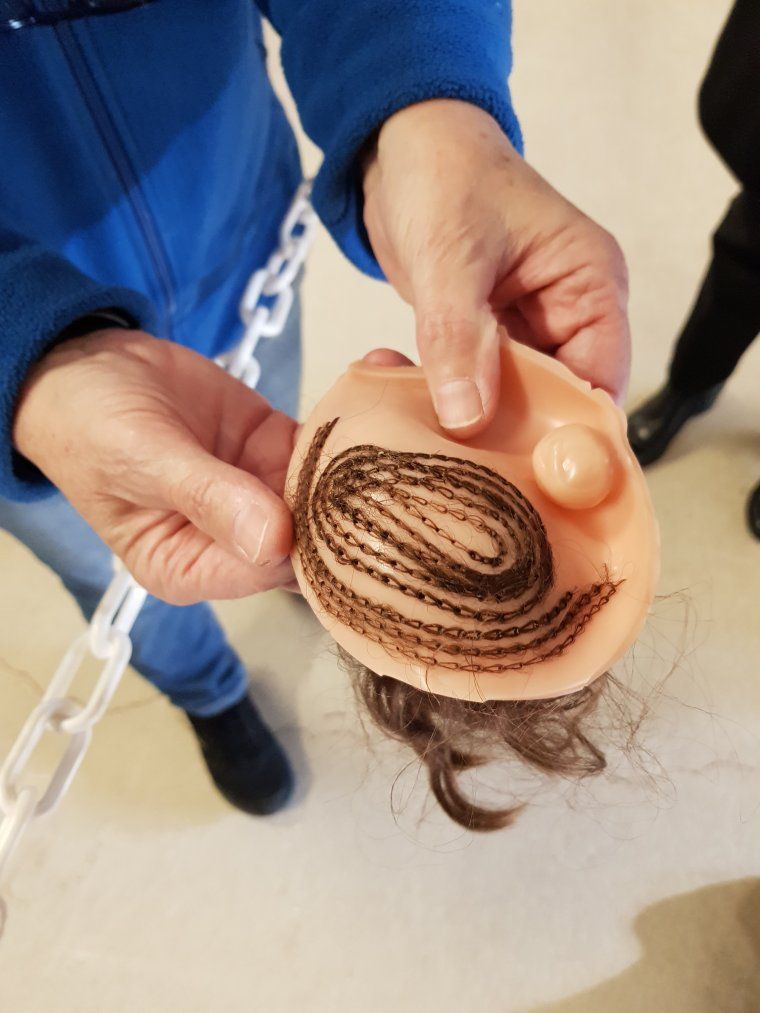 Quand la tète est prête, Les cheveux sont cousus à l aide d une machine à coudre en partant du centre de la tète jusqu'au front. .Des grands tubes conservent les cheveux de différentes couleurs et sont piqués dans le crane en formant un cercle