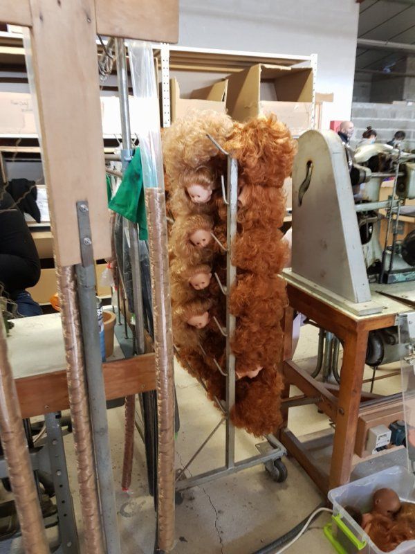 Quand la tète est prête, Les cheveux sont cousus à l aide d une machine à coudre en partant du centre de la tète jusqu'au front. .Des grands tubes conservent les cheveux de différentes couleurs et sont piqués dans le crane en formant un cercle